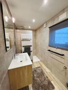 a bathroom with a sink and a flat screen tv at Chalet familial 2-6 personnes in Champdray +12 photos