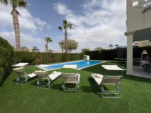 a group of lawn chairs and a swimming pool at Villa Sofía - 2 bedroom villa with private pool and garden in Baños y Mendigo