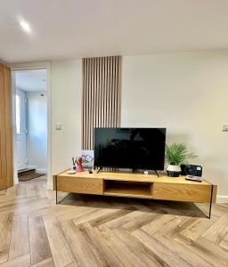 a living room with a flat screen tv on a table at Cozy Cottage Retreat in Portsoy