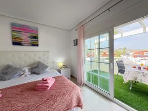 a bedroom with a bed with pink towels on it at Villa Sofía - 2 bedroom villa with private pool and garden in Baños y Mendigo +77 photos