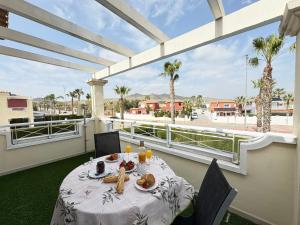 a table with food on a balcony with palm trees at Villa Sofía - 2 bedroom villa with private pool and garden in Baños y Mendigo
