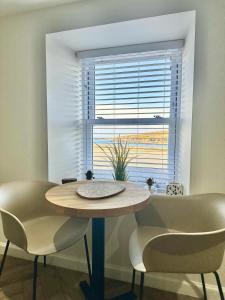 a table and two chairs in front of a window at Cozy Cottage Retreat in Portsoy
