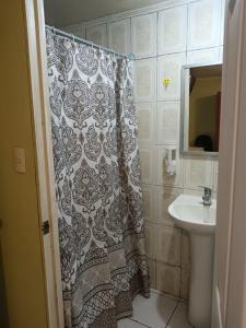 a bathroom with a shower curtain and a sink at Habitación G in Santiago