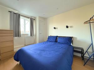 a bedroom with a blue bed and a window at Stunning 4 BR Townhouse for 8 With Free Parking in Dore