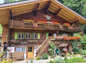 a wooden house with flower boxes on the balcony at Le Fôret - Cergnat in Le Sépey
