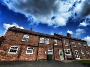 a large red brick building with white windows at Maypole Farm, Cawood in Selby