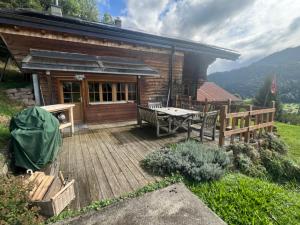a wooden deck in front of a log cabin at Le Fôret - Cergnat in Le Sépey