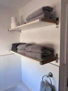 un bagno con mensole con asciugamani sopra di Beckers Place at No2 NLC in Carrickfergus a Carrickfergus