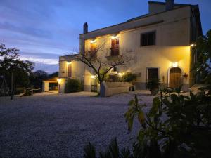 un grande edificio bianco con luci accese di notte di Tenuta degli Ulivi - Dimora Contadina a Montecorvino Rovella