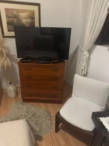 a living room with a television and a white chair at Old Town House Manosa Split in Split