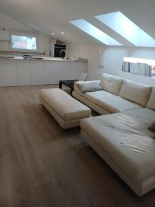 a living room with two white couches and a kitchen at Casa Vacanze Derby Appartamenti in Misano Adriatico