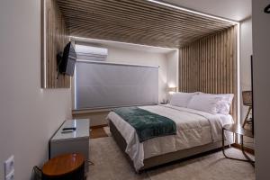 a bedroom with a bed and a large window at Cozy Home in Karpenisi