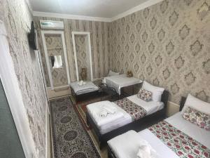 a living room with two beds and two mirrors at Madina-Mehribon in Bukhara