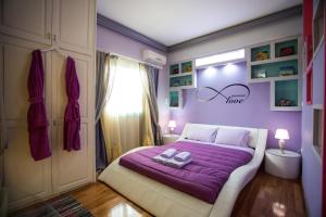um quarto com uma cama roxa com um cobertor roxo em La Terra Nostra em Corinto