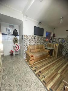 uma sala de estar com um sofá e uma TV na parede em Santo Antônio do Mineiro em Aparecida