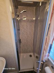 a shower with a glass door in a bathroom at Beachside, Family-friendly, WiFi, 6 berth caravans in Ingoldmells +20 photos