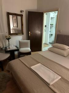 a bedroom with a bed and a chair and a mirror at Old Town House Manosa Split in Split +9 photos