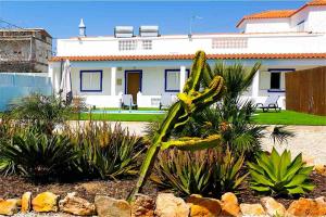 een plant voor een wit huis bij Villa Azul in Boliqueime