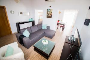 een woonkamer met een bank en een tafel bij Villa Azul in Boliqueime