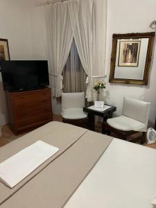 a bedroom with a bed and two chairs and a television at Old Town House Manosa Split in Split