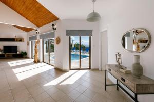 a living room with a mirror and a pool at Dream Villa in Tala with Private Pool, Sea & Mountain Views & Garden Retreat in Paphos City +135 photos