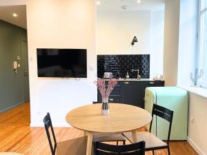 a table and chairs in a kitchen with a refrigerator at Le Cathedral View Colmar - Centre Historique - Parking privé gratuit in Colmar
