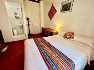 una camera da letto con un letto con una coperta colorata sopra di Killari B&B a Ollantaytambo