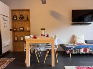ein Zimmer mit einem Holztisch, Stühlen und einem Sofa in der Unterkunft New Ski Apt in Three Valleys - L'Écrin in Brides-les-Bains + 9 Fotos