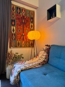 ein blaues Sofa im Wohnzimmer mit Lampe in der Unterkunft New Ski Apt in Three Valleys - L'Écrin in Brides-les-Bains