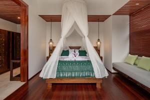 a bedroom with a bed with a mosquito net at E Sanctuary Resort Ubud in Ubud