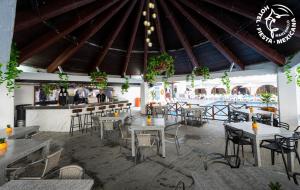 マンサニージョにあるHotel Fiesta Mexicanaのテーブルと椅子とバーのあるレストラン