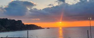 a sunset over a body of water with a rainbow at CASA CHITI TAORMINA in Taormina
