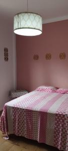 a bedroom with a bed with a pink and white blanket at Casa da Linda in Foz do Iguaçu
