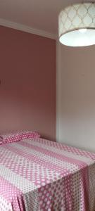 a bedroom with a bed with a pink and white blanket at Casa da Linda in Foz do Iguaçu