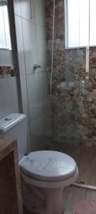 a bathroom with a toilet and a glass shower at Casa da Linda in Foz do Iguaçu +12 photos