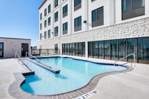 a large swimming pool in front of a building at Wingate by Wyndham San Angelo in San Angelo