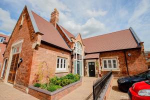 a brick house with a car parked in front of it at 3 The Old School House in Worcester