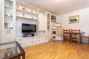 a living room with white cabinets and a television at Appartamento Iori in Canazei