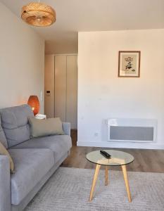 a living room with a couch and a table at La Perdrix in Sainte-Adresse