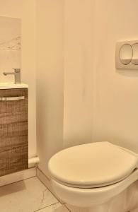 a bathroom with a white toilet and a sink at La Perdrix in Sainte-Adresse