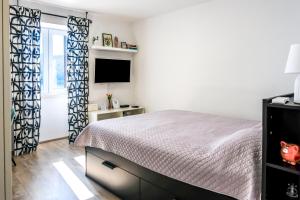 a bedroom with a bed and a flat screen tv at Studio apartment above promenade w terrace & parking in Rabac