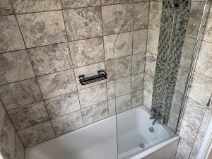 a bathroom with a shower and a bath tub at Modern 2 bedroom Terrace in Woolwich