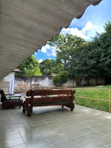 een bank op een patio met bomen op de achtergrond bij Hostel Lunar in Alto Paraíso de Goiás