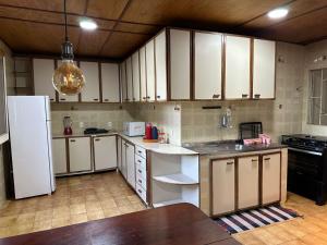 een keuken met witte kasten en een witte koelkast bij Hostel Lunar in Alto Paraíso de Goiás +26 foto's