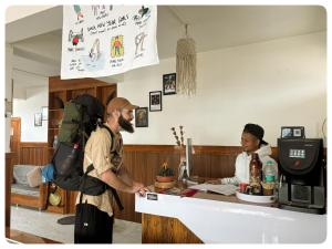 a man with a backpack standing in front of a counter at Stargaze Backpackers Shillong in Shillong