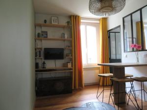 a living room with a table and a television at Beau T2 cosy ! Centre 200m Plage 400m in Dinard