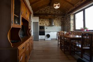 a kitchen with a table and a dining room at Refuxio de Lamas in Becerreá