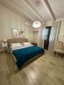 a bedroom with a large bed with a blue blanket at casa bv in Calatabiano +35 photos