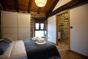 a bedroom with a large bed with towels on it at Refuxio de Lamas in Becerreá +31 photos