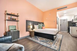 ein Schlafzimmer mit einem Bett und einem Fernseher in der Unterkunft Bold & Floral Little Richard Getaway in Macon